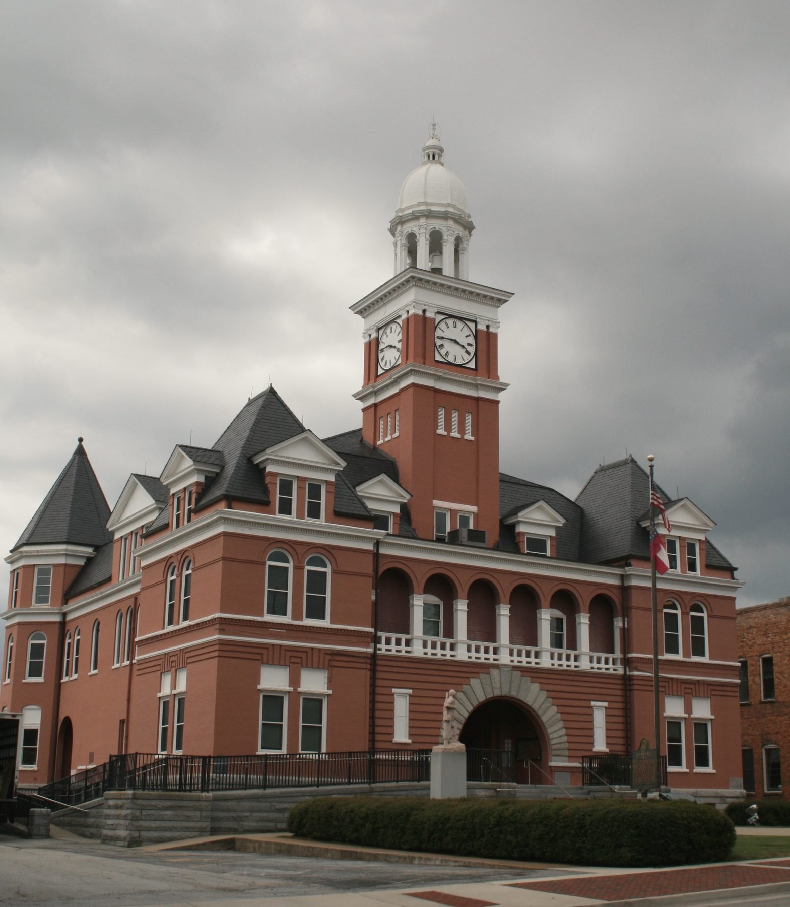 The red brick Elbert County Courthouse with its clock tower under grey sky